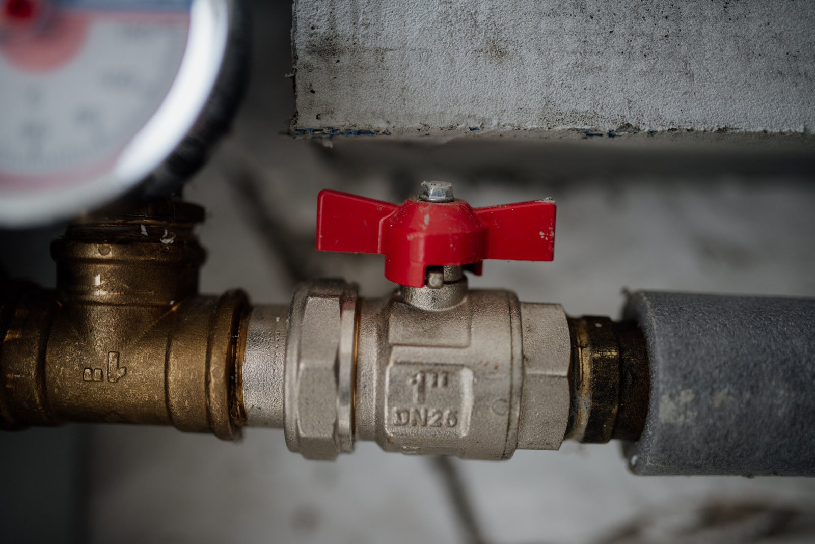 Close-up of an industrial valve and pressure gauge during maintenance