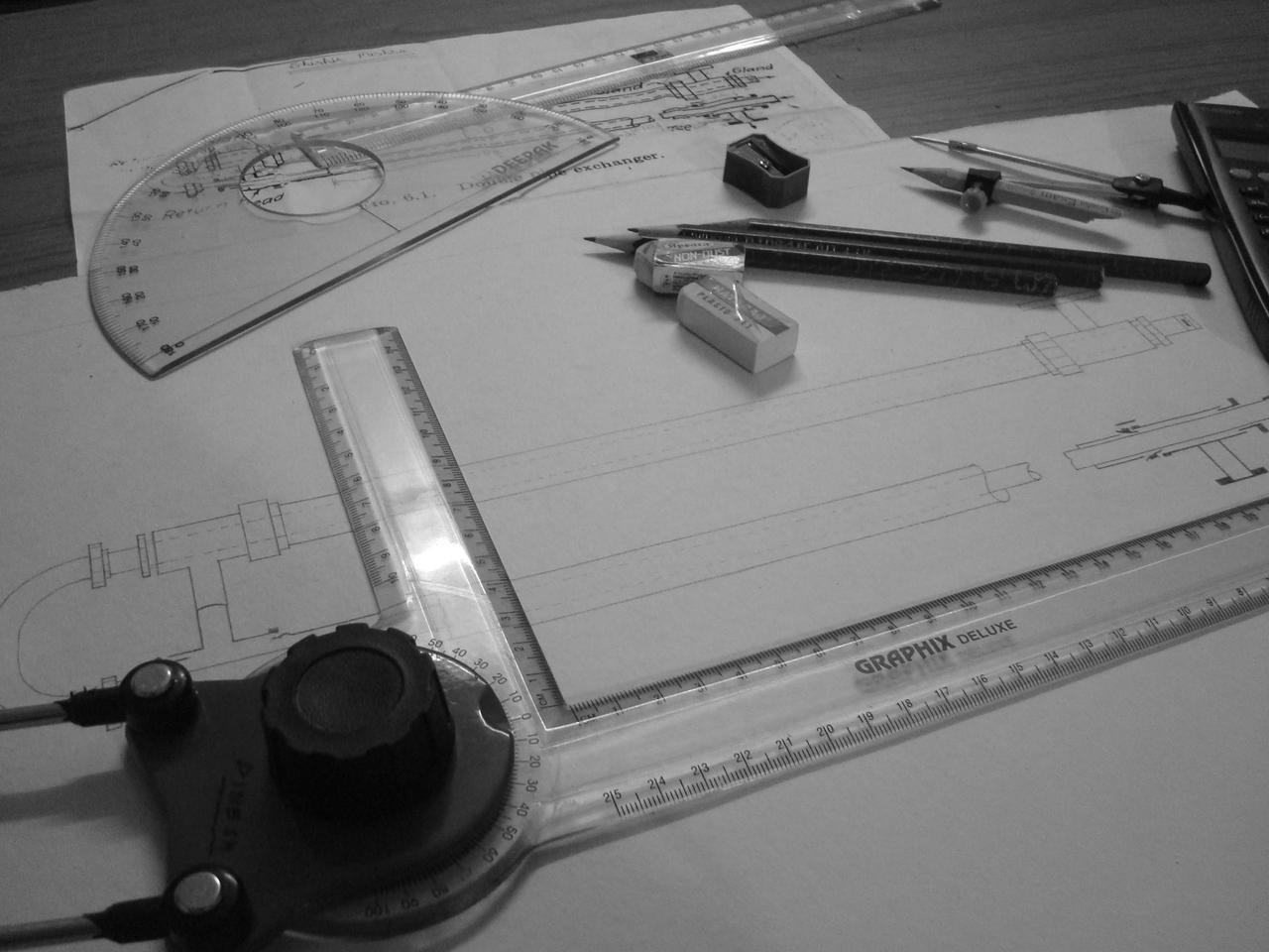 Technical engineering design drawings on a desk