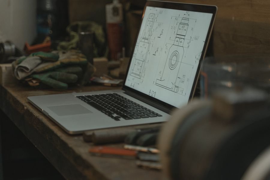 Reviewing technical drawings and project specifications on laptop
