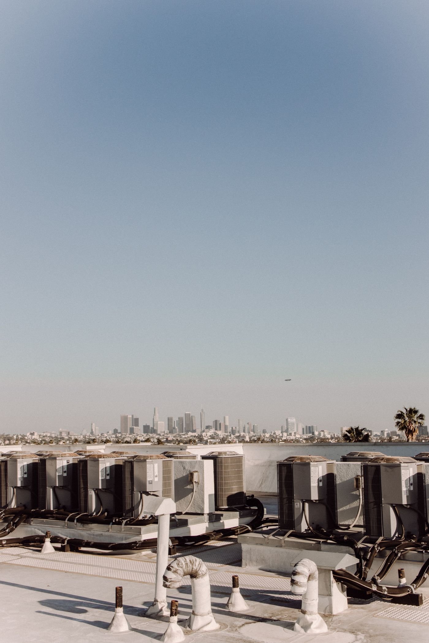 Rooftop HVAC equipment overlooking a city skyline