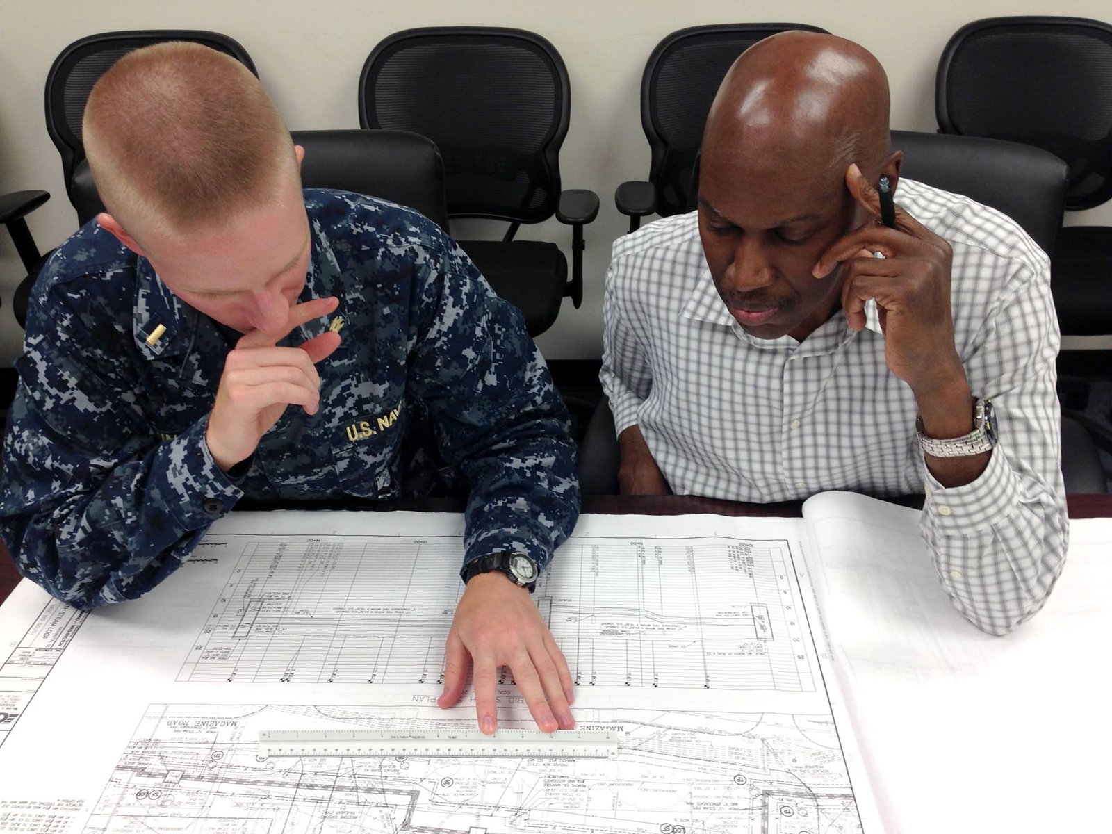 Engineers reviewing technical drawings used to prepare an OEM specification